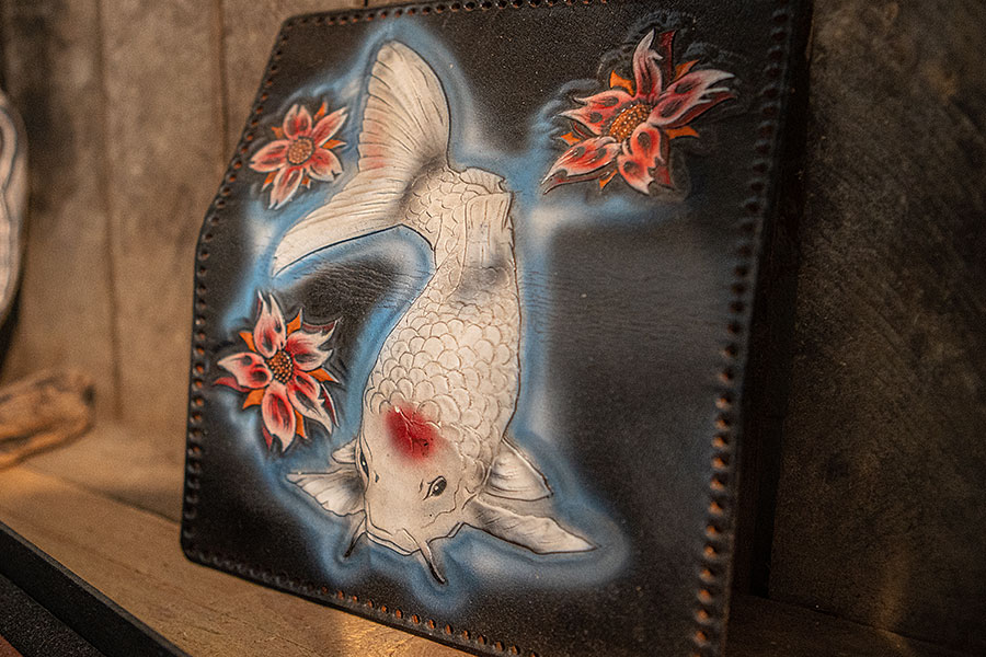 punziertes Lederkunstwerk, welches einen japanischen Koi umgeben von Blüten zeigt