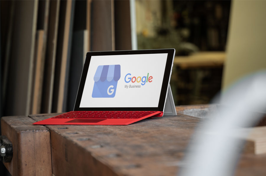 Laptop steht auf einer Werkbank aus Holz. Der Bildschirm zeigt das Logo von Google My Business